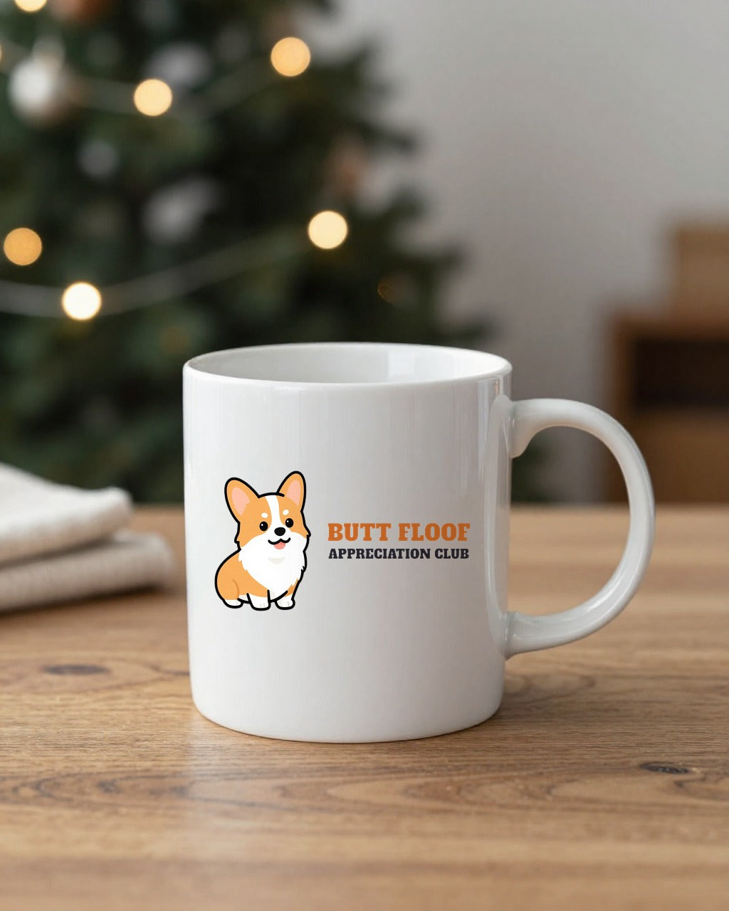 Corgi Butt Appreciation Club mug on a table by a Christmas tree