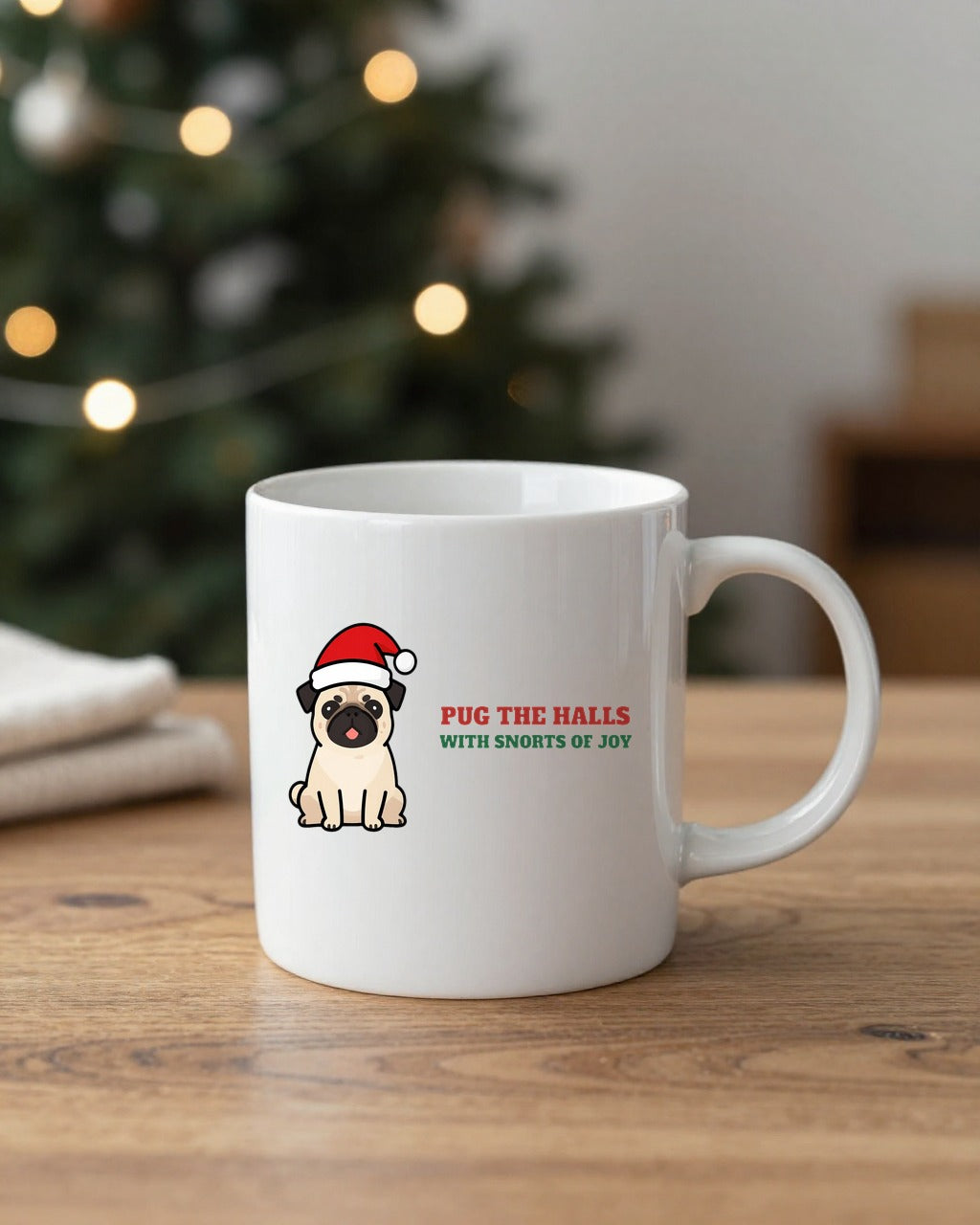 Pug the Halls Christmas pug mug on a table by a Christmas tree